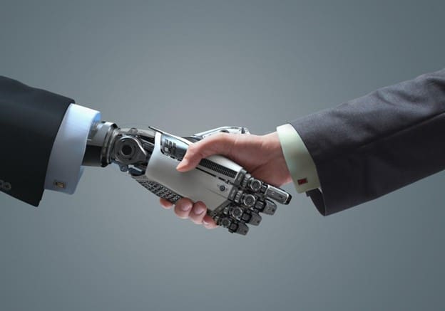 Main de robot qui sert la main d'un humain